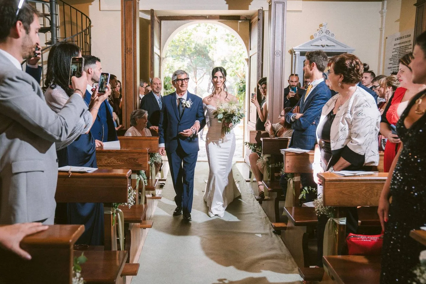 Una sposa, accompagnata dal proprio padre, percorre la navata della chiesa prima presso il santuario di Dipodi a Pianopoli · foto 13