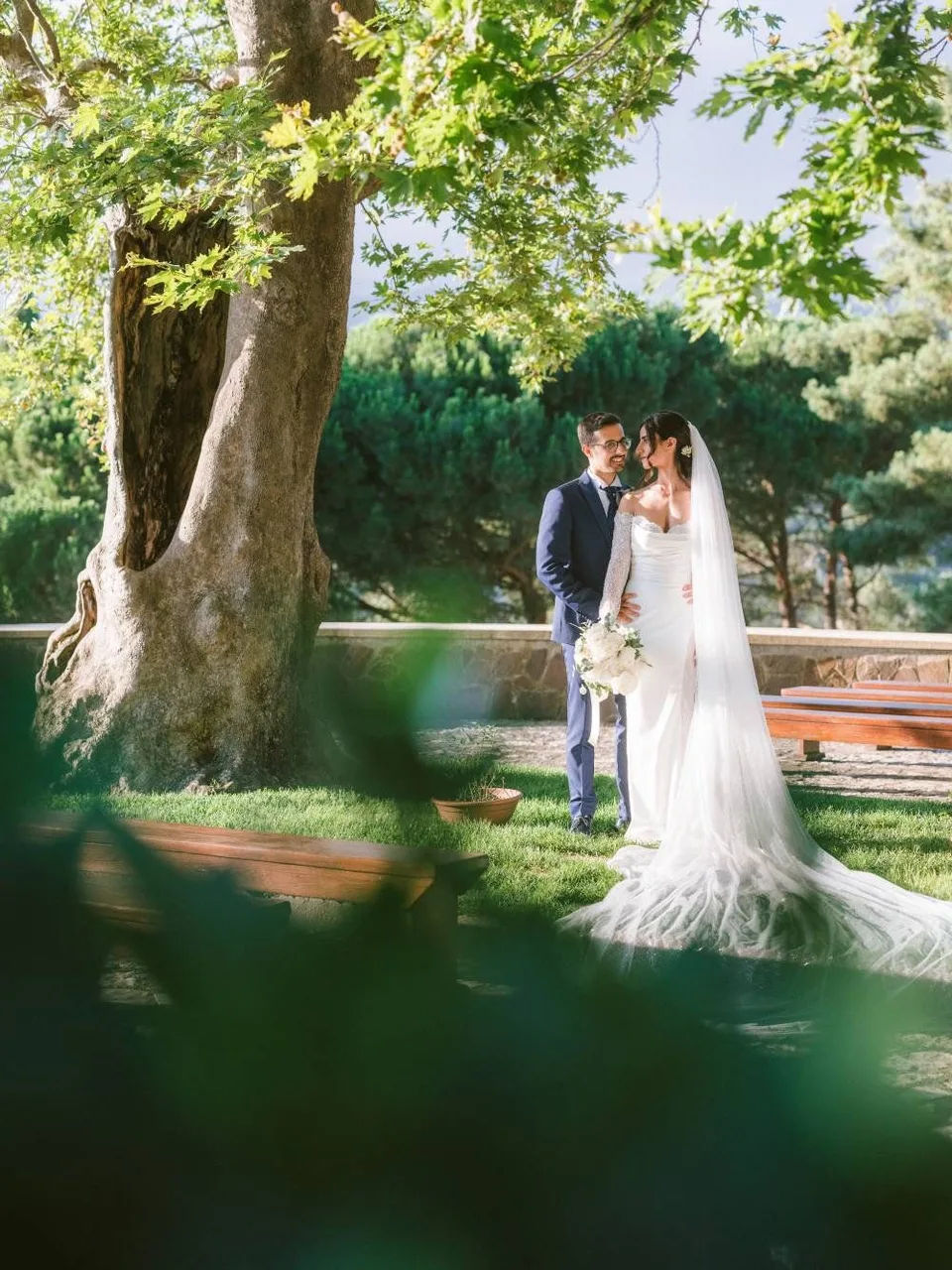 Sposi sorridenti in un giardino, sotto un grande albero, in un'atmosfera romantica e luminosa presso il Santuario di Dipodi a Pianopoli · foto 14